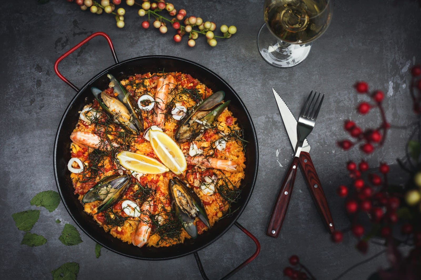 Paella vue de dessus dans sa poêle, sur table sombre