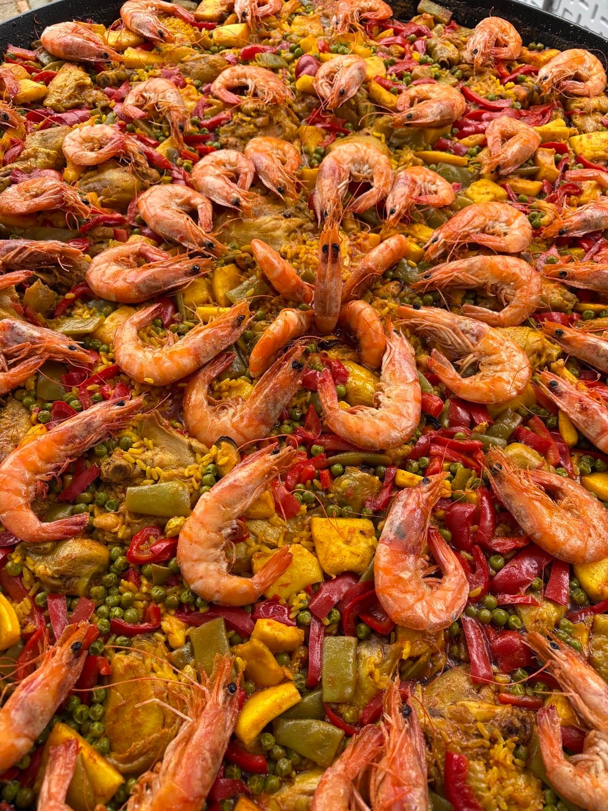 Paella géante aux gambas et aux poivrons servie lors d'un repas de quartier