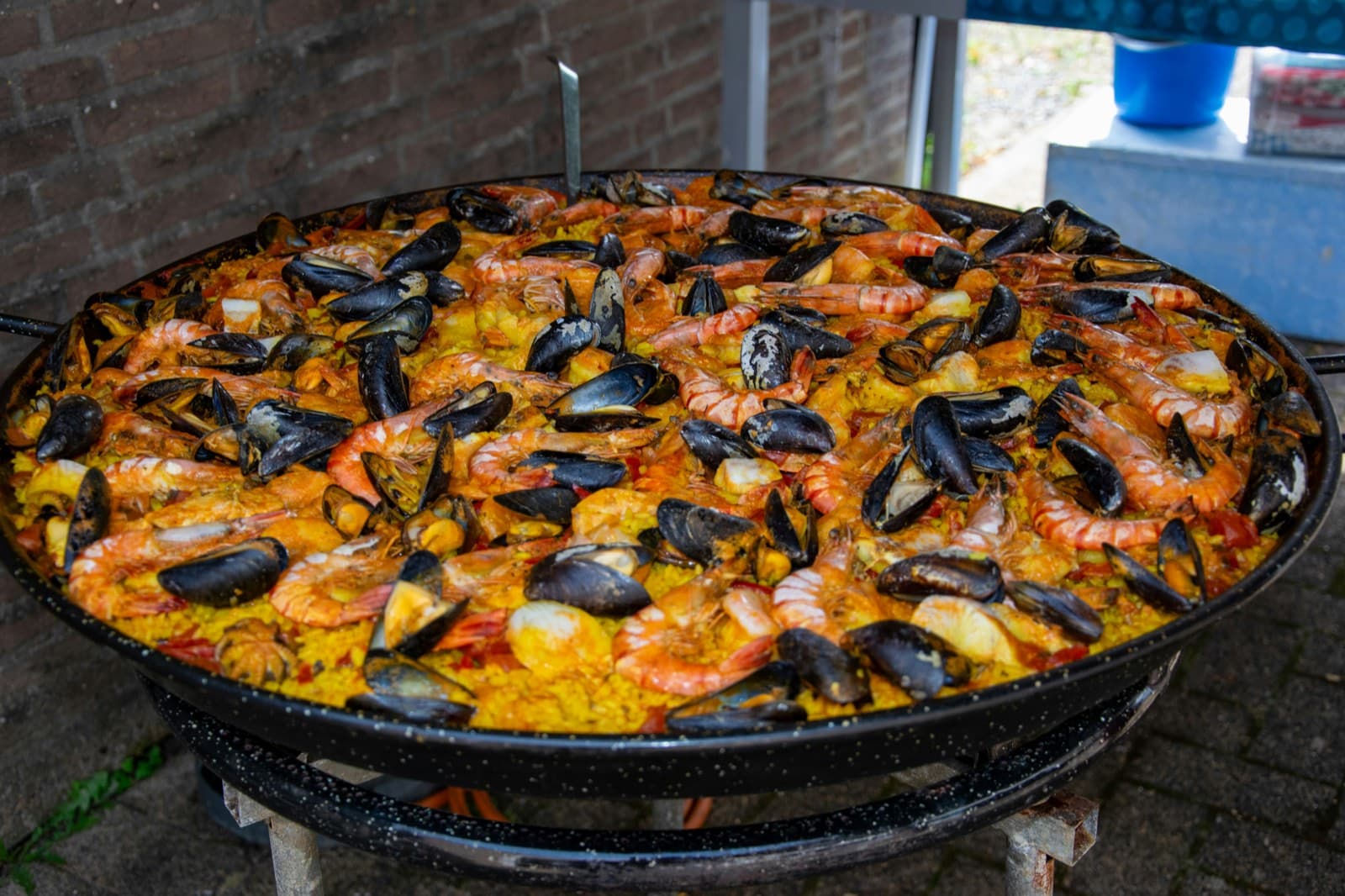 Grande poêle de paella aux gambas et aux moules, prête à servir une cinquantaine de convives